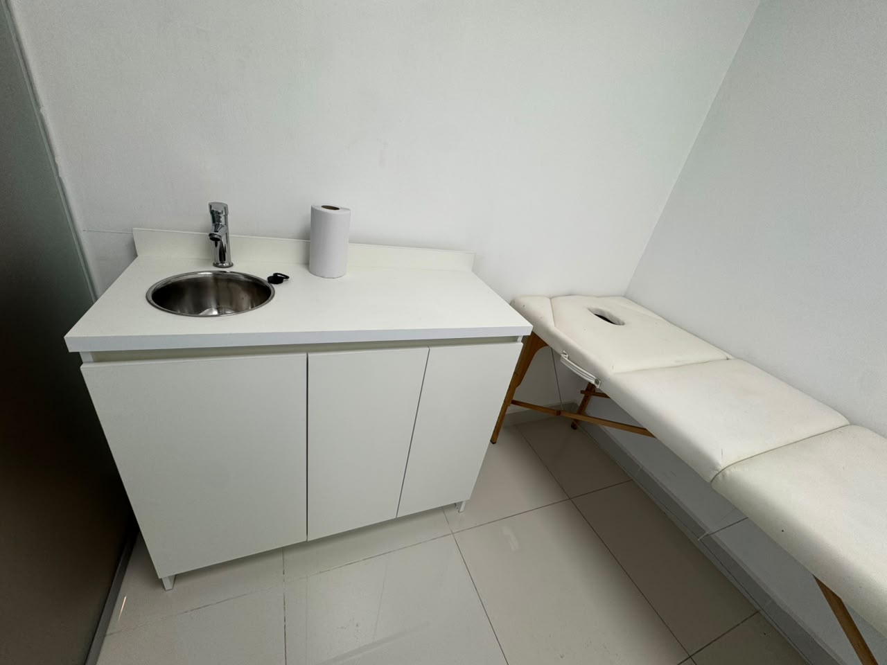 Mueble con lavamanos junto a la camilla